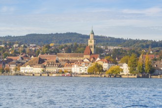 Lakeside city view with church tower, colorful trees and wooded hills, Überlingen, Lake Constance,