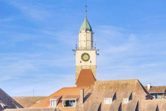 A remarkable church tower with clock over red roof tiles in sunlight, Überlingen, Lake Constance,