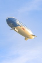 Zeppelin flies in evening light with clear sky, shows advertising message, Überlingen, Lake