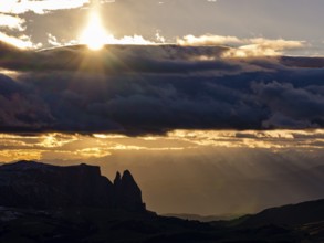 View of the Sciliar under dark clouds with sun, Dolomites, Trentino, South Tyrol, Italy
