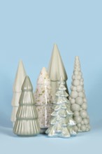 Beautiful different shaped light green ceramic Christmas trees on blue background