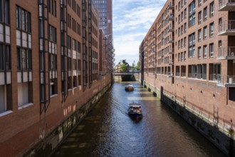 Boats on canal between red brick buildings, warehouses in Hamburg's Speicherstadt, Hamburg, Germany