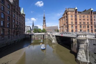 Boat on the Kleines Fleet canal with Kannengießer bridge and tower of the main church of St.