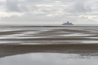 A ferry of the Wyker Dampfschiffs-Reederei (W.D.R.) sails at low tide in the Wadden Sea between