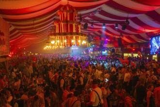 Lively and colourful celebration in a large beer tent full of people and bright decorations,