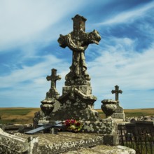 Crosses stand tall against a colorful sunset sky, showcasing the beauty of an ancient cemetery.