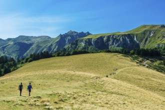 Auvergne Volcanoes Regional Park. Groups of hikers traverse a rugged path in the beautiful Sancy