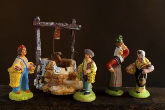Colorful Provençal terracotta Santons figurines showcase characters engaged in various activities,