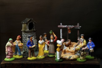 Colorful Provençal terracotta Santons figurines showcase characters engaged in various activities,