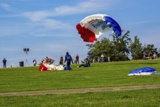Parachutists have landed after an aerial acrobatic performance during an air show on the Rossfeld