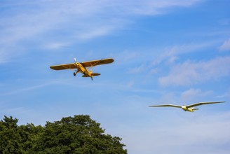 A Piper PA-18 Super Cub tows a glider during an air show at the Rossfeld in Metzingen-Glems,
