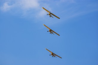 Three Piper PA-18 Super Cub aeroplanes of the Bravo Lima Formation flying in formation during an