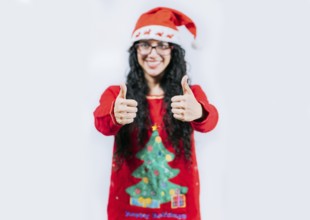 Young woman in Christmas sweater gesturing Ok with thumbs up. isolated. Smiling girl in Christmas