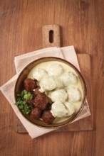Swedish meatballs in cream sauce, plate on a wooden table, homemade, no people