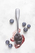 A spoon with blueberry jam, on a white table, breakfast, top view, homemade, no people