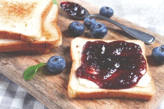 Toast with blueberry jam, on a wooden chopping board, breakfast, homemade, no people