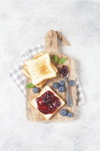 Toast with blueberry jam, on a wooden chopping board, breakfast, homemade, no people