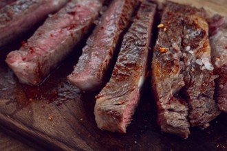 Medium rare, sliced rib eye steak, grilled cowboy steak, on a chopping board, close-up, homemade,