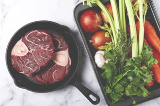 Sknuckle on the bone, raw meat for ossobuco, in a cast-iron pan, baking sheet with vegetables, top