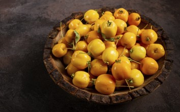 Yellow small apples, Chinese varieties, in a wooden bowl, top view, no people
