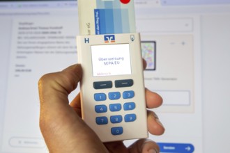 Online banking symbol image: Scanner for online banking in front of a bank website opened on a PC