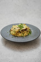 A beautifully plated dish featuring risoni pasta mixed with rich porcini mushrooms