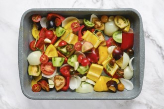 A vibrant mix of fresh vegetables including bell peppers, tomatoes, onions, and zucchini on a