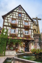 Emperor Constantin fountain in front of a half-timbered house in Kaysersberg
