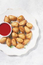 Fried mini chebureks, with sauce, on a decorative plate, hard light, no people