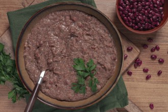 Red bean lobio, a traditional Georgian dish, on a wooden table, homemade