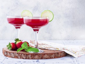 Refreshing cocktail in an elegant glass with lime and strawberries, sunshine, no people