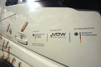 The passenger door of an electric lorry shows which state institutions have paid and approved