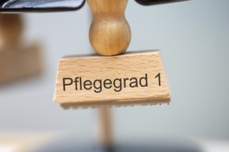 (Photomontage) Close-up of a stamp with the inscription PFLEGEGRAD 1