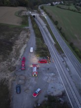 Aerial view of an operation site on a road and railway tracks, rural landscape, fire drill in the