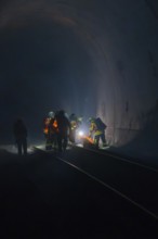 Group of firefighters in the tunnel, illuminated by a light source, fire drill in the new tunnel of