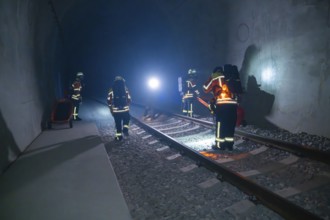 Firefighters working in the tunnel in the dark, accompanied by light sources, firefighting exercise