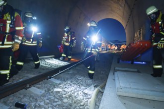 Firefighters in a tunnel at night, strong light illuminates the scene, firefighting exercise in the