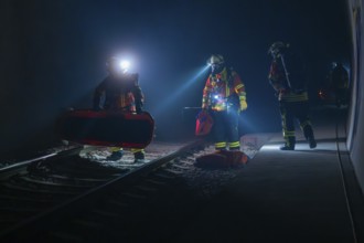 Group of firefighters during a night-time operation on the tracks, firefighting exercise in the new