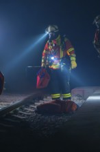 Fireman illuminates the tracks with a torch, nocturnal atmosphere, fire drill in the new tunnel of