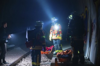 Group of firefighters ready for action on railway tracks at night, firefighting exercise in the new