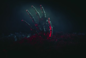 A skeleton hand shining menacingly from the earth in the light, Halloween