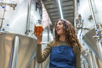 Woman tasting craft beer for quality control, evaluating the quality of the beverage in a modern