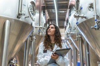 Woman scientist in a white lab coat with clipboard conducting quality control inspection in a