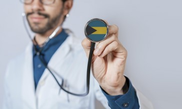 Doctor holding stethoscope with Bahamas flag. Bahamas health and care concept. Bahamas flag on