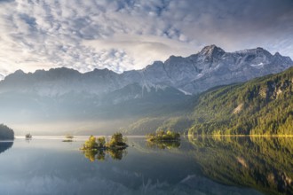 Morning atmosphere at the Eibsee lake with the Zugspitze, small islands in the first light, Grainau