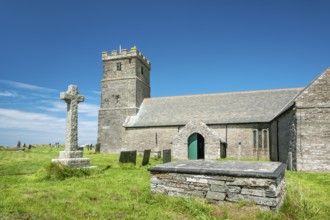 The Norman church of St Materiana with graveyard and stone cross, Tintagel, Cornwall, England,