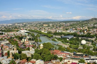 Beautiful view of Tbilisi showing the river, bridges, and green parks on a sunny day
