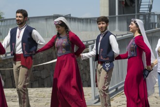 Group in colourful traditional costume holding hands while dancing, folklore, Tatev, Tatev, Syunik