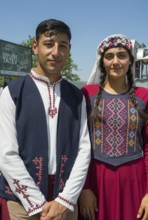 Close-up of a couple in traditional traditional costume in front of a sign, folklore, Tatev, Tatev,