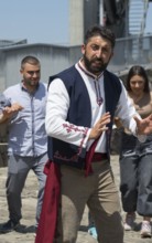 Man in folkloric clothes dancing, accompanied by other people, folklore, Tatev, Tatev, Syunik